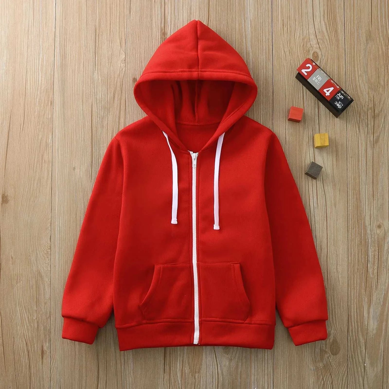 Kids red wind proof jacket zip sweatshirt hoodie with long sleeves and front pockets on wooden background